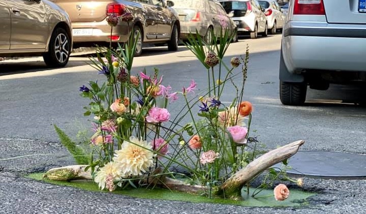 O florărie din București acoperă gropile cu aranjamente florale „pentru a atrage atenția asupra unor reguli sau nereguli din jurul nostru”